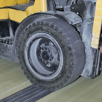Image of a tire driving over structural fiberglass heavy duty pultruded grating.