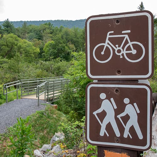 Rocky Gap Bridge in the background w/ bike and hiking sign in forground