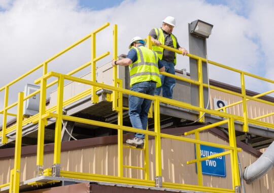 Two men in safety gear using ReadySeries platform, rails and ladders made of fiberglass reinforced polymr