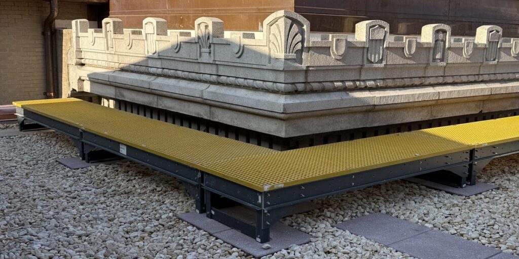 Temporary walkway on rooftop made from fiberglass-reinforced polymer.