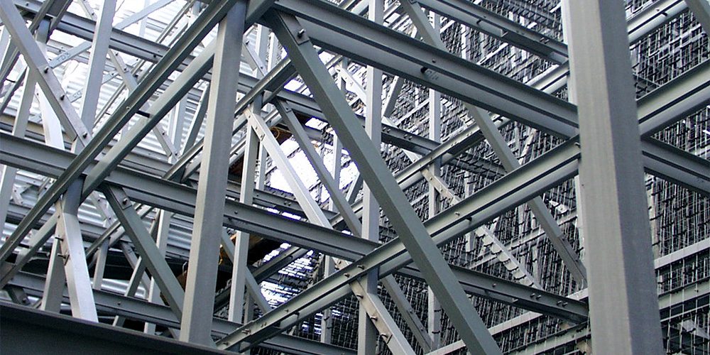 Close-up of a fiberglass reinforced plastic (FRP) frame structure with intersecting metal beams, creating a geometric pattern. The scene conveys industrial strength and complexity.